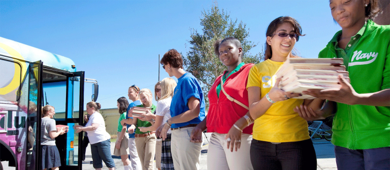 SCAD faculty, staff, students, and alumni deliver books to a local school.