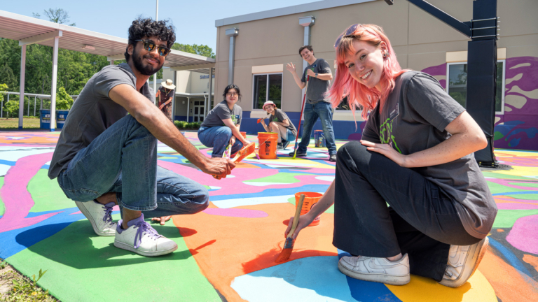 SCAD SERVE students paint a basketball court