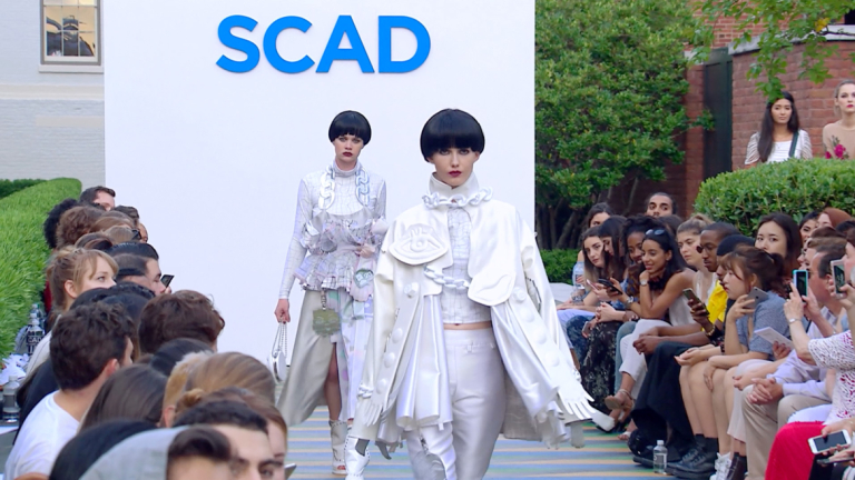 Two models walk down SCAD runway wearing white and sporting bowl cuts