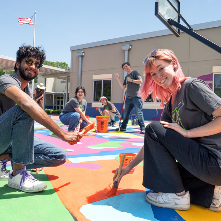 SCAD SERVE students paint a basketball court